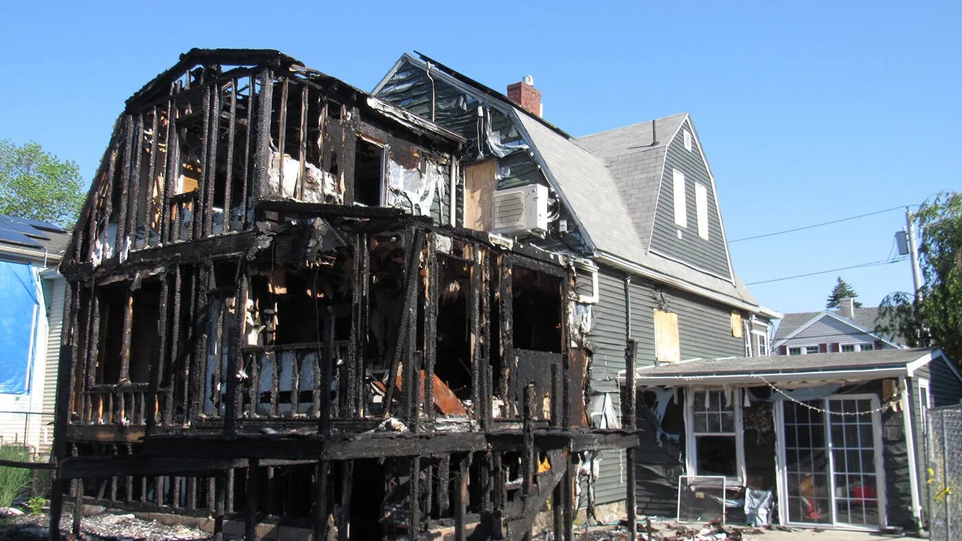 Fire damage assessment professional examining damaged structure